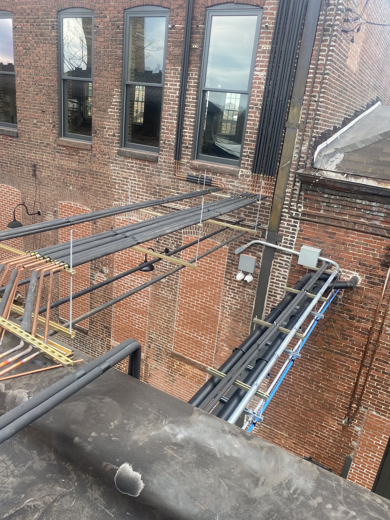 Commercial refrigerant piping installation on a brick building
